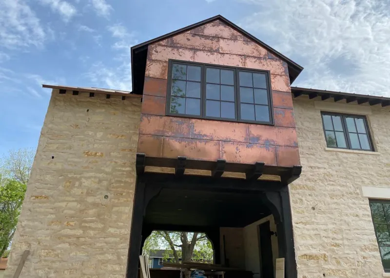 Copper metal panel facade on a stone building for Skylight Installation in North Andover