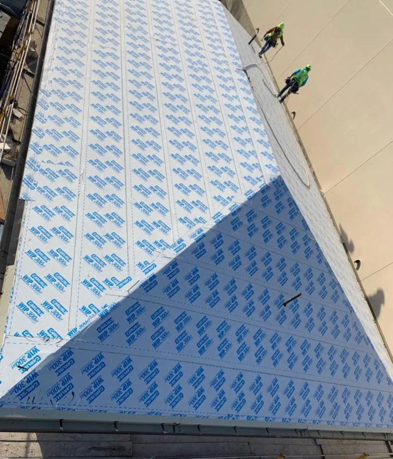 Professional roofers installing underlayment on a metal roof in North Andover